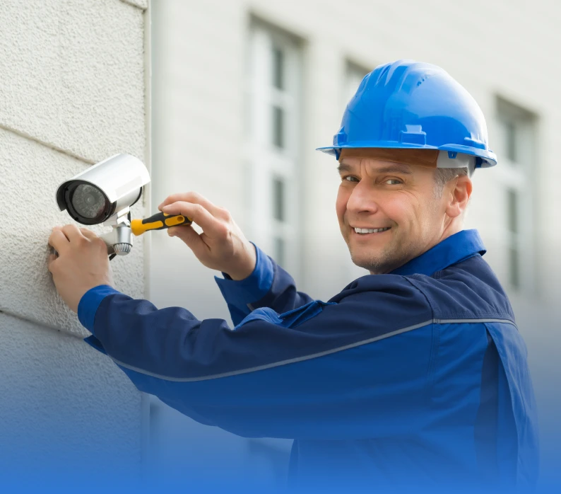Man fixing outdoor security camera